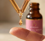 Golden drop of Pūraka Face Oil Serum falling from glass dropper