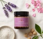 Pūraka Hydrating Face Scrub flatlay with jojoba granules, macadamia, lavender and geranium petals