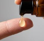 Drop of Pūraka Hydrating Super Serum falling from amber glass dropper bottle