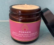 Pūraka Anti-Ageing Cream with Rose Absolute, Geranium and Jasmine — open amber glass jar showing the rich natural cream texture