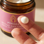 Pūraka Active Day Cream on fingertip showing rich white cream texture