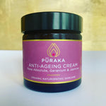 Pūraka Anti-Ageing Cream with Rose Absolute, Geranium and Jasmine in amber glass jar against a gold background, 60ml