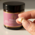 Close-up of Pūraka Anti-Ageing Cream texture between fingers, showing the rich natural formula