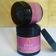 Pūraka Brightening Soothing Hand Cream with Vetiver, Orange and Lavender stacked with the Activated Charcoal Deep Cleansing Mask in amber glass jars against a gold background