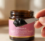 Deep black Pūraka Charcoal Mask on a spatula with jar in background