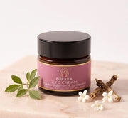 Pūraka Eye Cream jar with elemi leaves, spikenard root and white flowers on blush stone